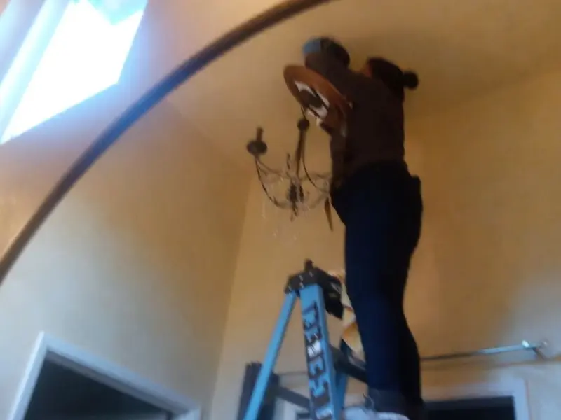 Electrician installing a chandelier in a Atlantic residence